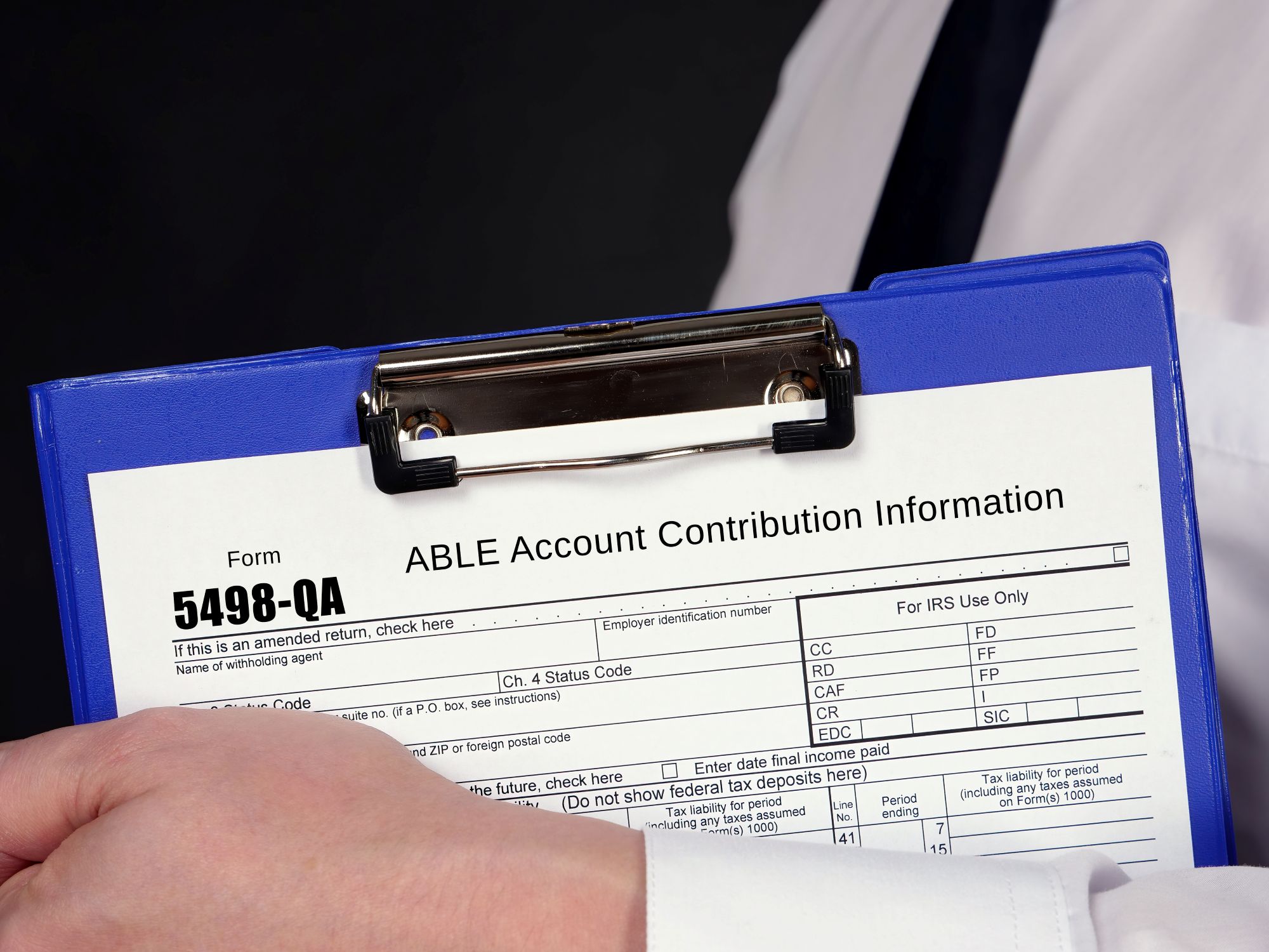Man holding clipboard displaying ABLE account information